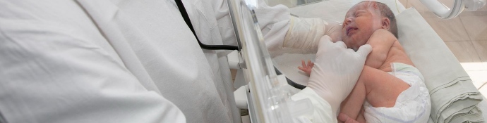 Doctor watches premature newborn