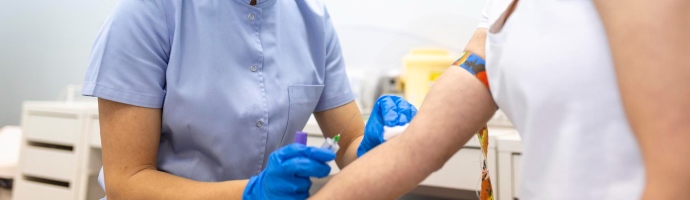 medical technologist doing a blood draw services for patient lab assistant with sterile rubber gloves