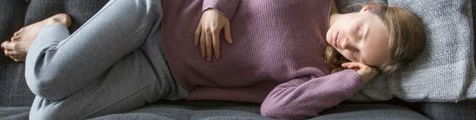 woman laying on grey sofa